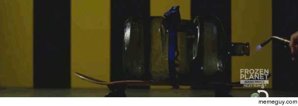Alcohol inside a water cooler bottle strapped to a skateboard is ignited to show propulsion