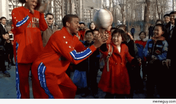 North Korean girl spinning a basketball assisted by a Harlem Globetrotter