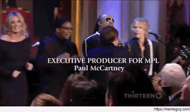 Stevie Wonder reaching for a microphone stand that Paul McCartney knocked over