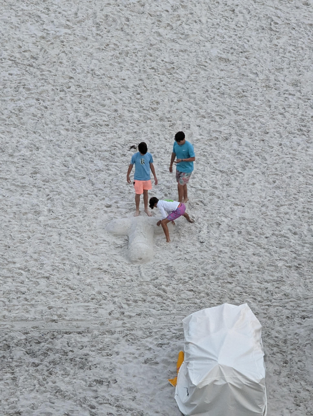 These kids making a unique sandcastle on the beach