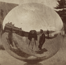 A man taking a selfie with a stereoscopic camera in the s with a mirror globe