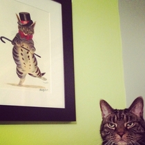 A photo of a cat next to the painting I made of him Did I do ok