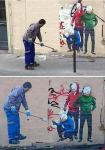 A worker removed the graffiti  the artist returned and painted it and drew the worker as he wiped it