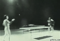 Bruce Lee playing ping pong with nun chucks