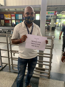 Driver with placard outside an Indian airport for delegates for Asian Musculoskeletal Conference