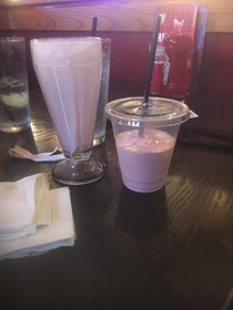 Full glass milkshake into a to-go cup