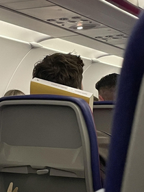 Guy using his book as a pillow on my flight