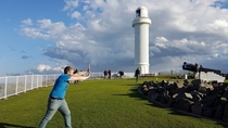 My friend asked me to take a picture of him pushing the lighthouse