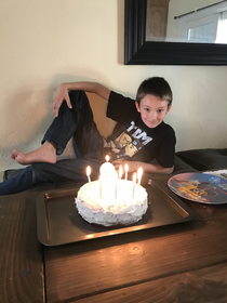My son turned  today and insisted I take his picture like this in front of his cake