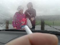 No smoking with kids in the car law is ridiculous Just look at them out there in the rain