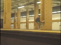 Skateboarder jumps over the subway tracks