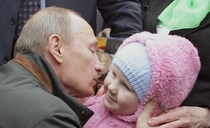Vladimir Putin kissing a baby Just prior to this the baby attacked a journalist bit his leg and drew blood