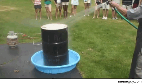 A drum filled with steam being sprayed with water