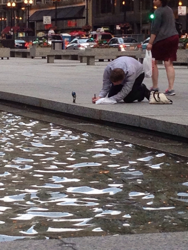 A Man taking pictures of his Optimus Prime figurine in the middle of downtown Chicago No fucks given