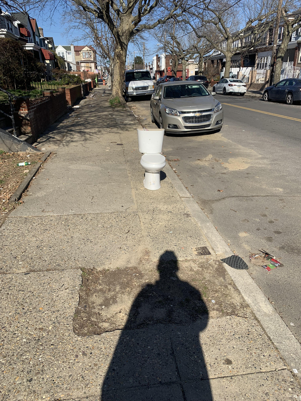 A toilet casually on the sidewalk