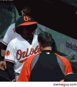 Adam Jones walking through the dugout with the Oriole Birds hat 