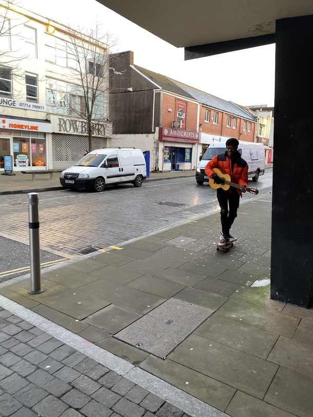 am nearly on a dreary Monday morning in Swansea and this kid passed playing the guitar on his wheelie-board Spreading that joy like butter