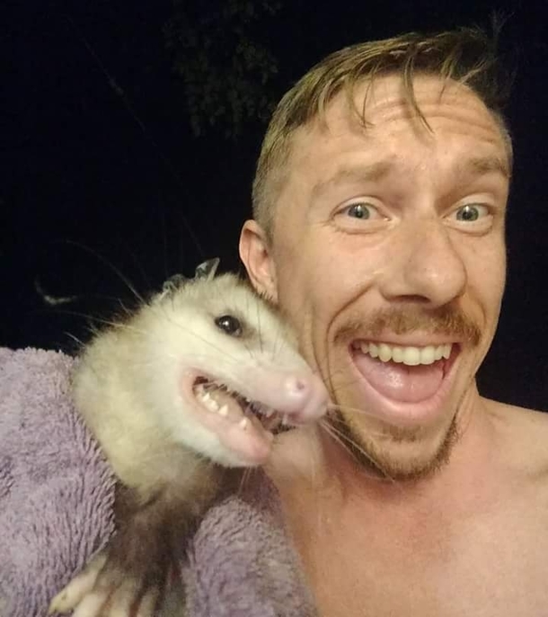 An opossum got into my buddys house and he snapped a selfie with it while he was carrying it out