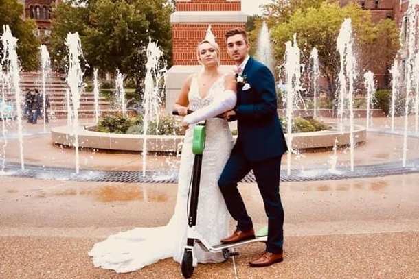 Bride and groom take a photo with the scooter that is the culprit for the brides cast She broke her arm in three places at the rehearsal dinner messing around Find the humor in everything I guess