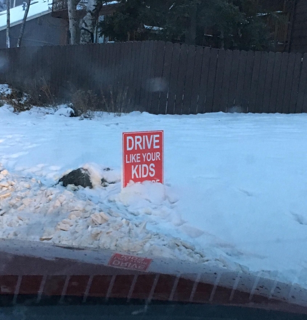 Drive like your kids live here sign trolled by snow