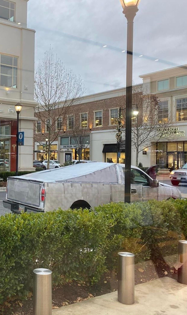 Early Cybertruck Prototype parked in front of a Tesla Store