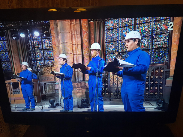 French TV broadcast is showing a concert in Notre Dame but because the cathedral is still under construction after the fire they are all wearing hardtops