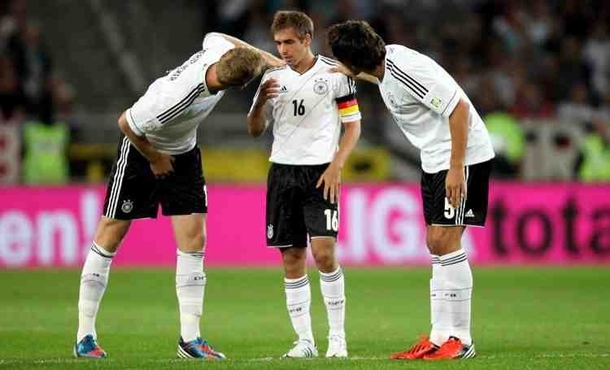 Germanys central defenders  and  bending down to talk to their captain 