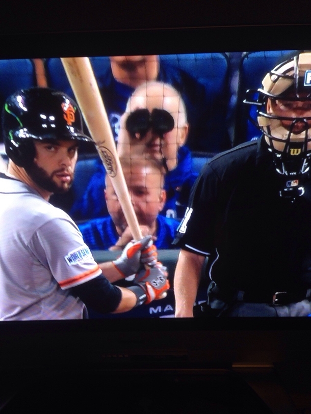 Guy at the World Series using binoculars in the second row