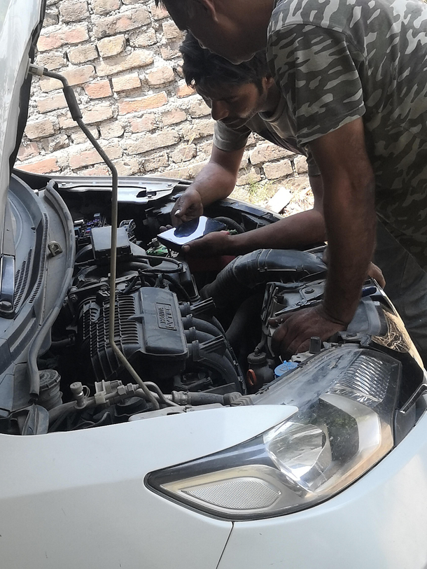 Guys who came to fix my car are watching a tutorial to fix the car