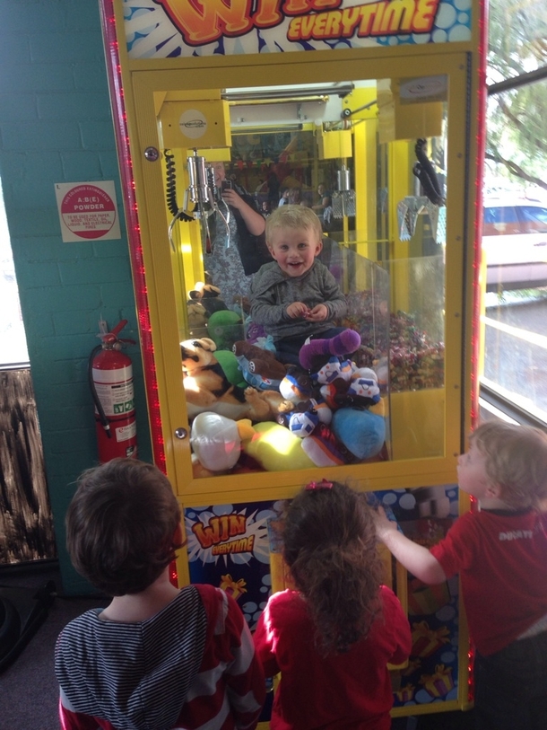 Kid stuck in skill tester machine Threw toys and lollies down for his fans while waiting to be rescued
