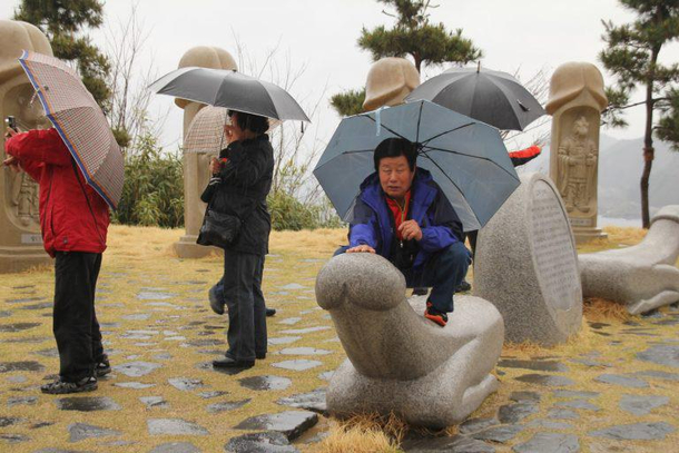 Korean man in ritual at the statue in Hae Shin Dong Park GyeongSsang Dong Korea