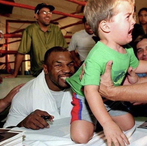 Mike Tyson biting a childs shirt