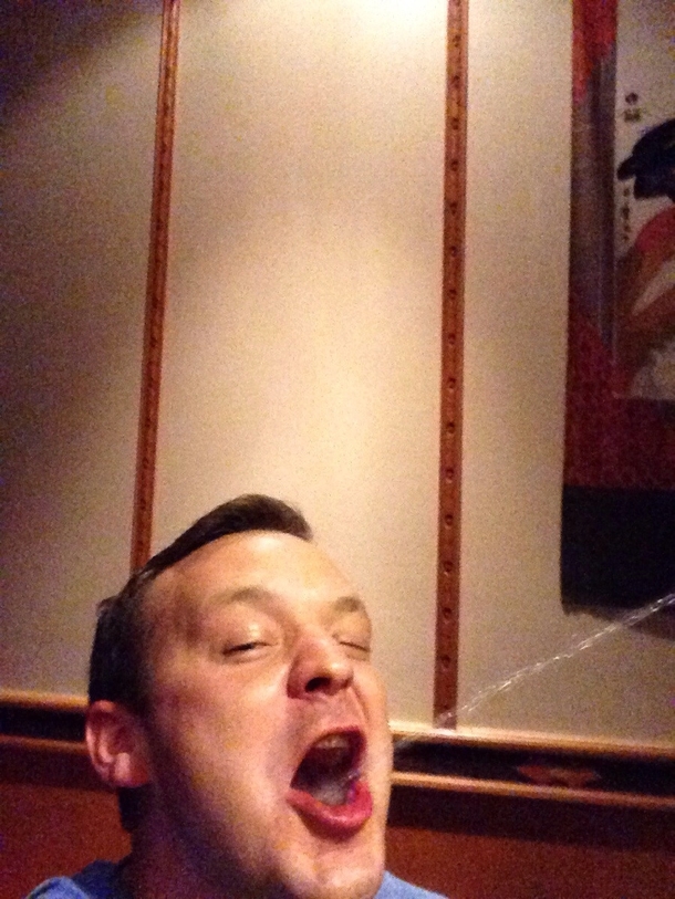 My brother took a selfie while getting sake shot in his mouth at a hibachi restaurant