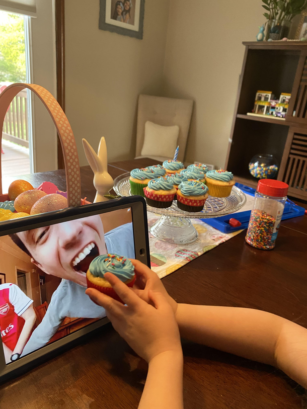 My daughter feeding my brother a cupcake during his virtual birthday party