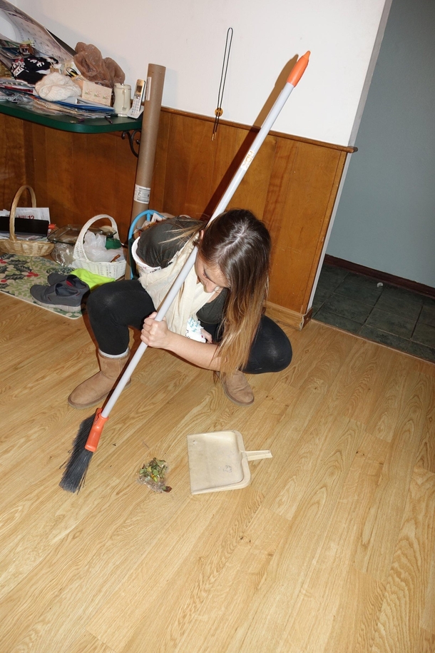 My girlfriend insists on showing me how to sweep up properly despite her broken arm