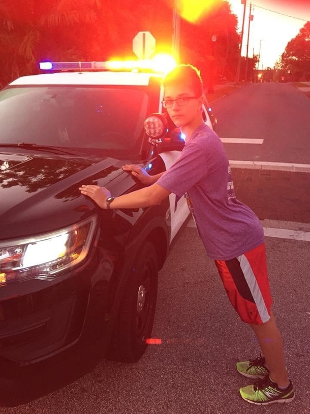 My son needed to have a recent photograph for a high school hes applying to This morning we ran a race that required local roads to be closed off A police officer at the starting line humored us with this picture and even offered to put him in cuffs
