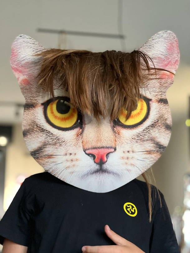 my son wearing a cat mask with his hair on top