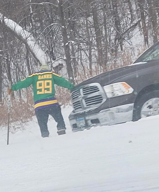 Passed a guy outside of Minneapolis on the freeway today He spun out This is him wearing a hockey jersey trying to dig his truck out with a hockey stickonly in Minnesota