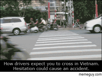 Pedestrian crossing heavy traffic in Vietnam