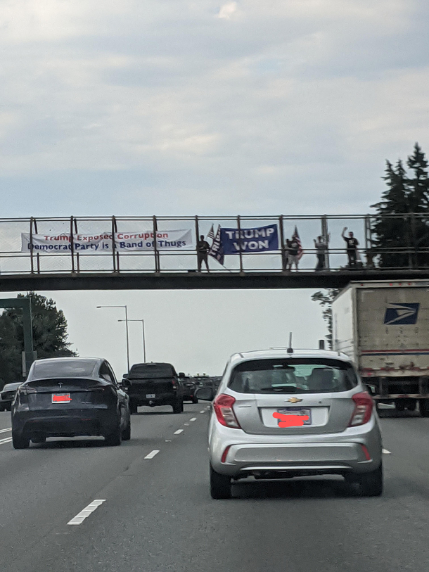 People who stand on highway overpasses with signs why