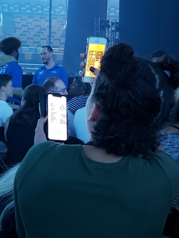 She is using Morse Code to talk to her friends with her phone flashlight at a Childish Gambino concert