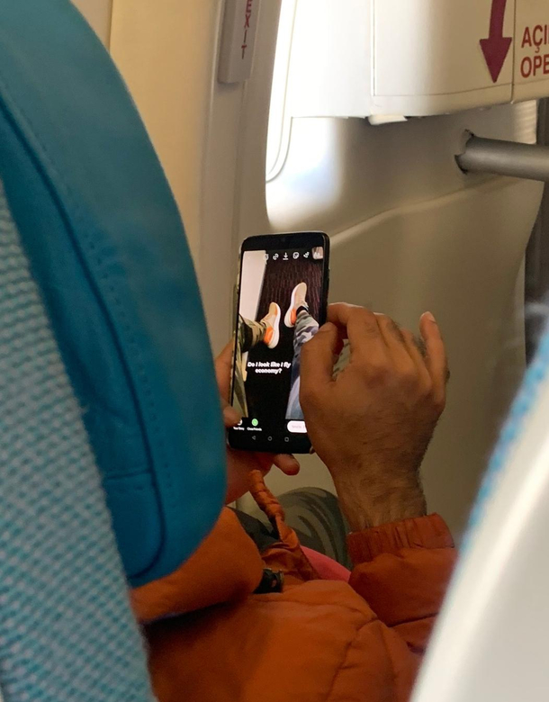 Sitting in exit row Do I look like I sit in economy posted on social media while sitting in economy 