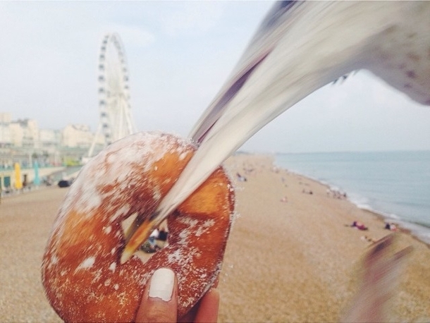 Taking too long to take a photo of her food on the beach