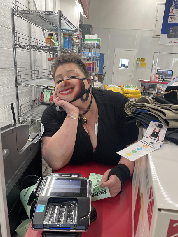 The cashier at my local Costco is smiling under the mask