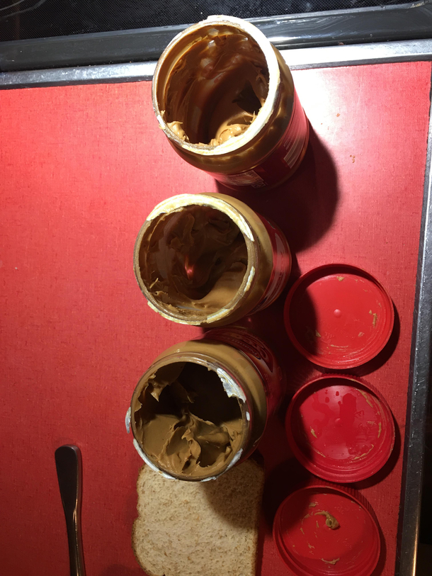 The insanity Three open jars of peanut butter Who lives like this