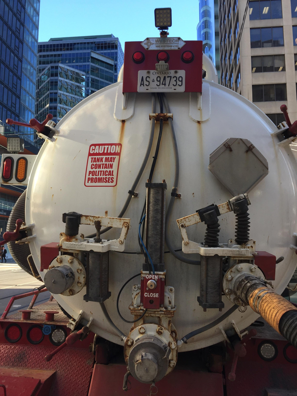 The sign on the back of a sewage vacuum truck 