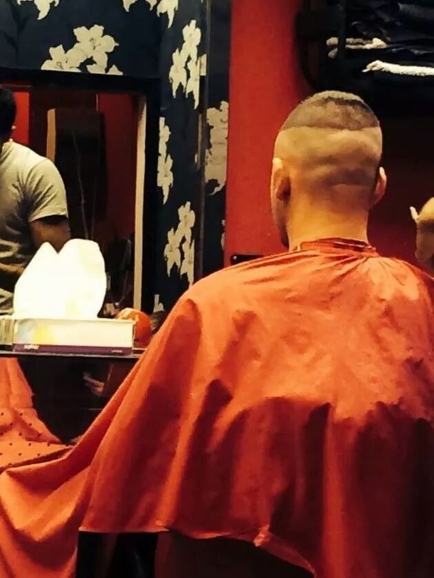 Theres a sloths face on the back of this mans head