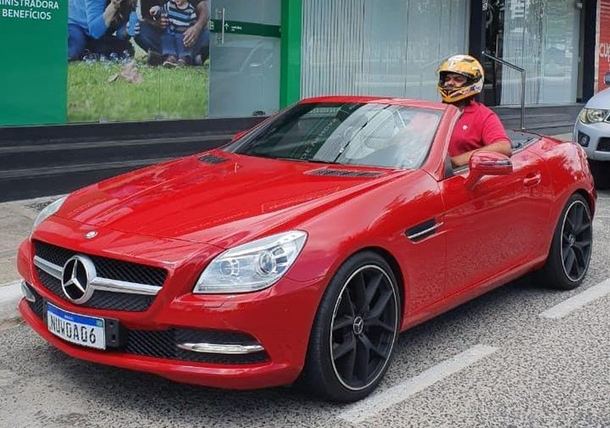 This guy bought the car of his dreams but apparently his too big for it he cant close the roof and has to use a helmet to drive it 