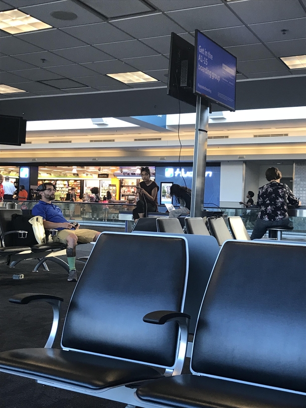 This guy wasnt letting a delayed flight ruin his day Hooked up a PlayStation to airport monitors