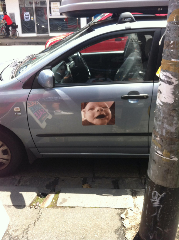 This is one of the nicest close-up photos of a babys face with a sepia filter printed into a decal and installed on the side of a car that Ive ever seen